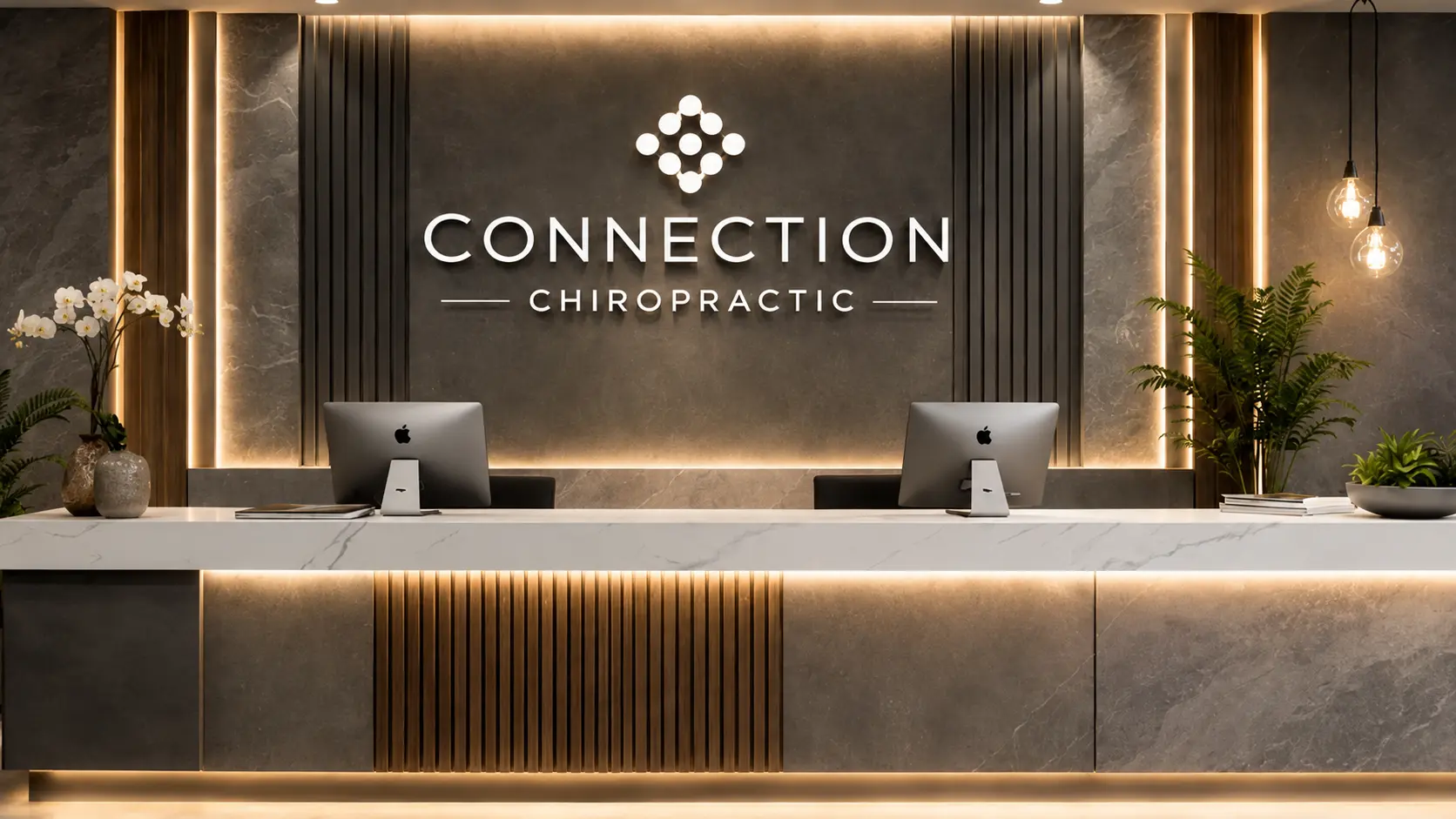 Recepción comercial de clínica quiropráctica con muro de piedra gris iluminado, logotipo retroiluminado, listones de madera, mostrador de mármol blanco y plantas decorativas